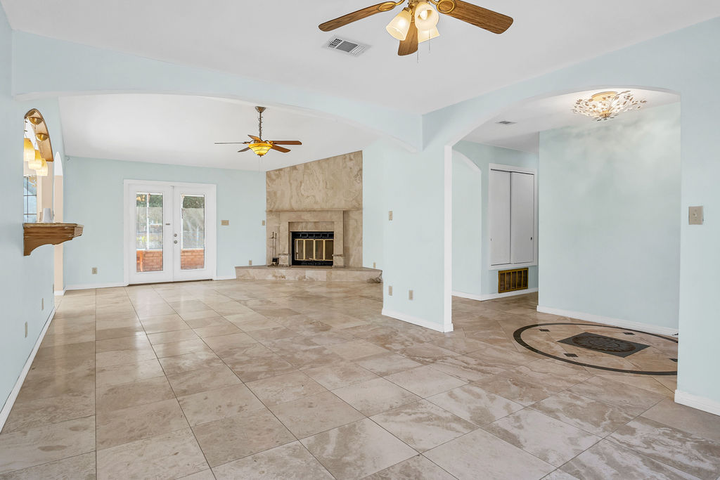 Empty living room with fireplace and natural light in a Florida home